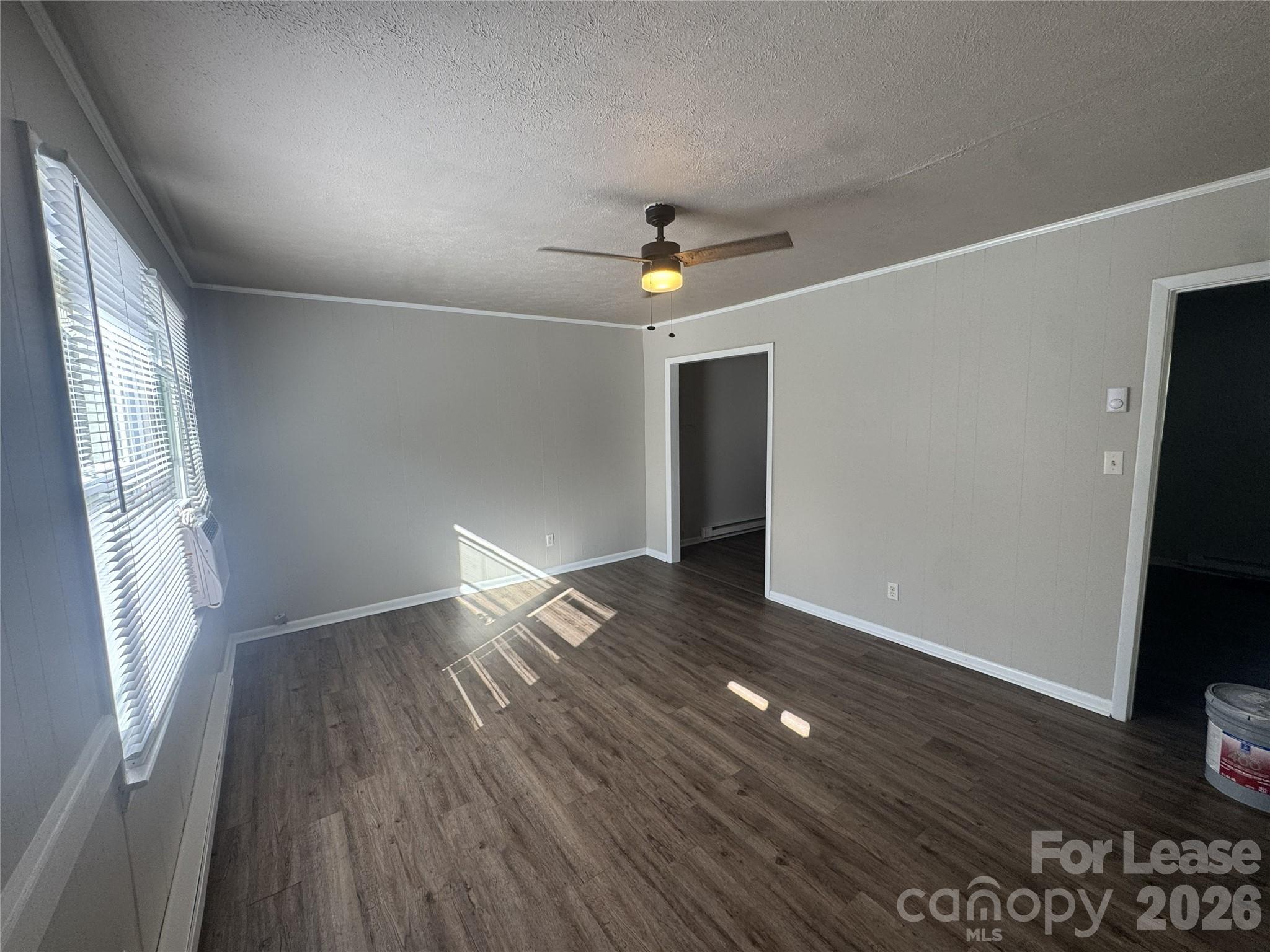 337 Laurel Street Hudson, NC 28638 - Photo 2 of 7 an empty room with wooden floor and windows