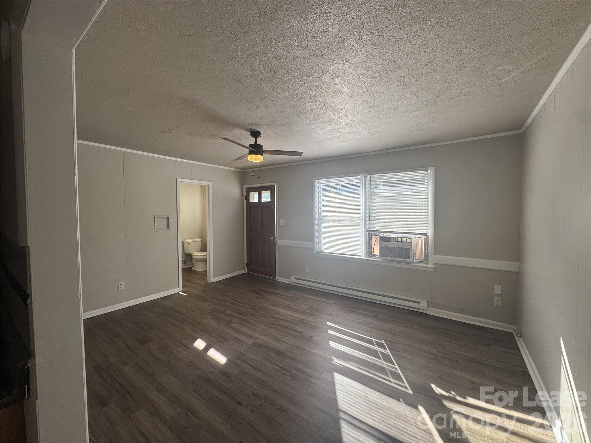 337 Laurel Street Hudson, NC 28638 - Photo 3 of 7 an empty room with wooden floor and windows