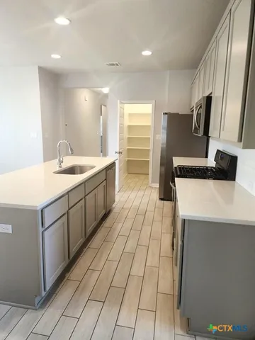 a kitchen with stainless steel appliances a sink stove and cabinets