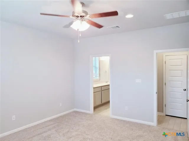 an empty room with closet and a chandelier fan