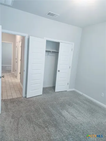 an empty room with closet and mirror