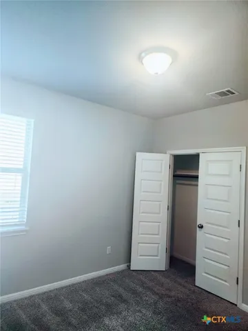 an empty room with a hallway and closet