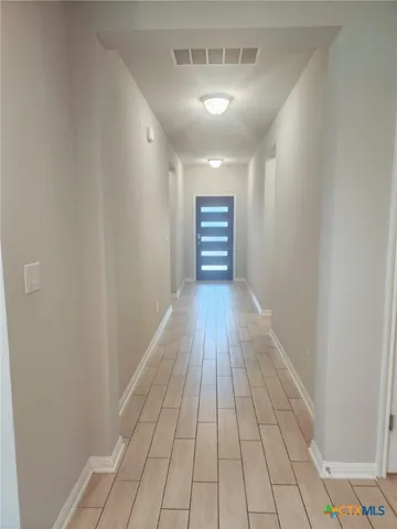 a view of empty room with wooden floor