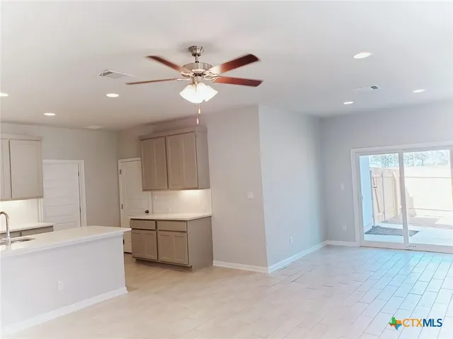 a living room with kitchen island furniture and a ceiling fan
