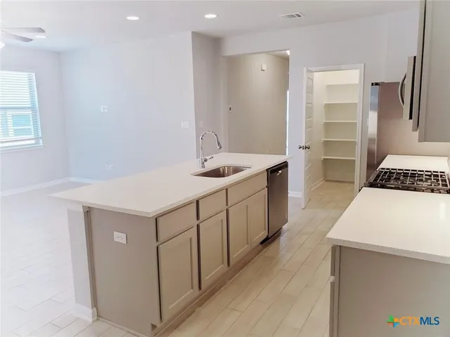 a kitchen with a sink stove and cabinets