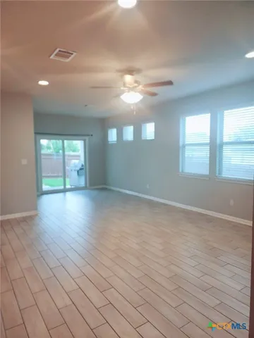 a view of empty room with window and wooden floor