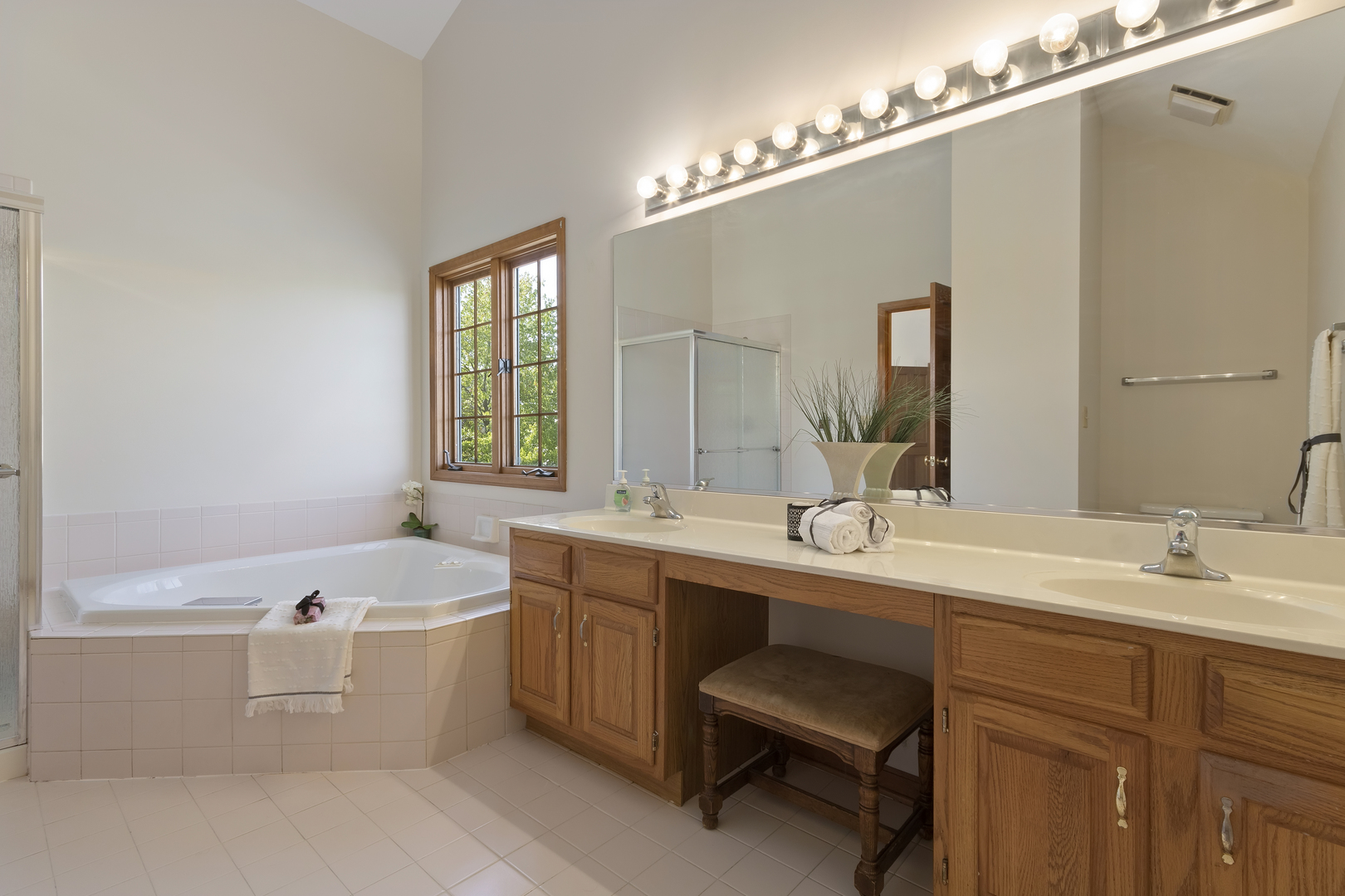 17929 West Pond Ridge Circle Gurnee, IL 60031 - Photo 18 of 28 a bathroom with a double vanity sink a large mirror and bathtub