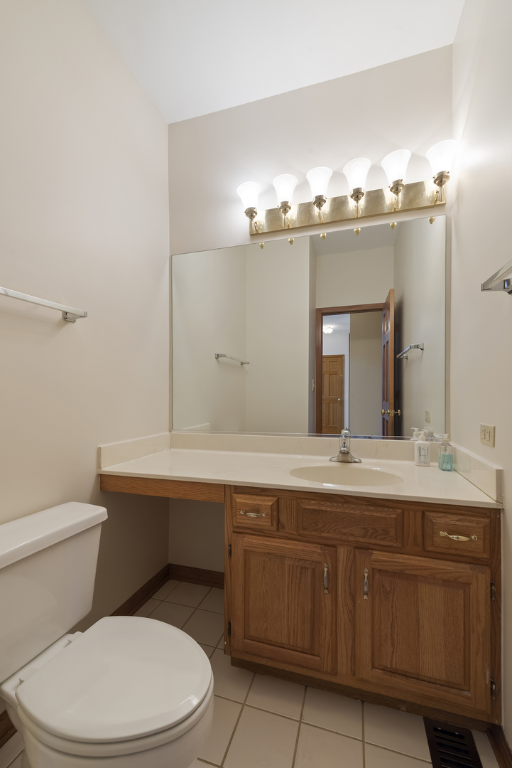 17929 West Pond Ridge Circle Gurnee, IL 60031 - Photo 24 of 28 a bathroom with a toilet a sink and mirror