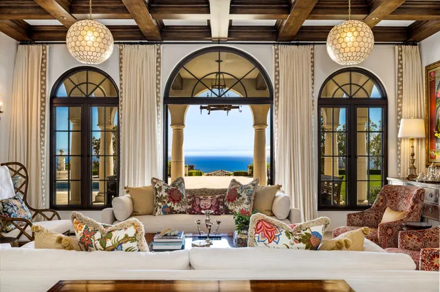 a living room with furniture a fireplace and large window