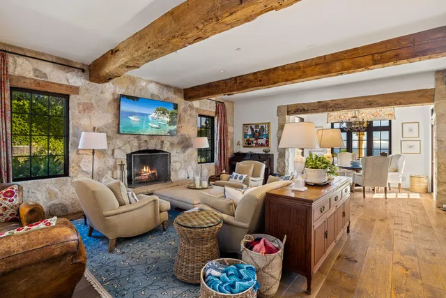 a living room with furniture fireplace and a large window