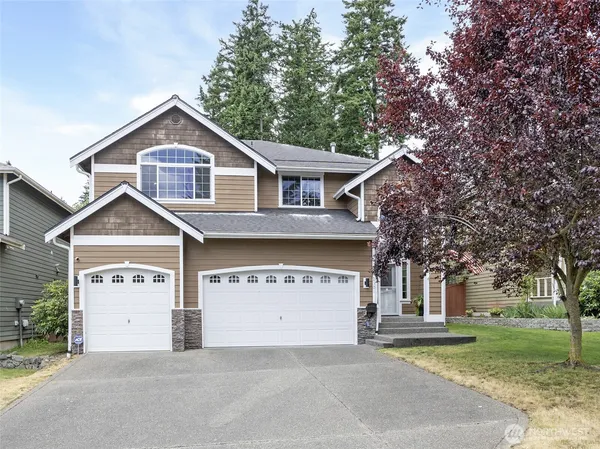 a front view of a house with a yard and garage