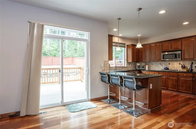 a kitchen with granite countertop a stove refrigerator and microwave