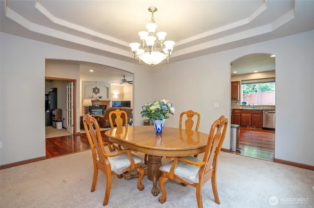 a dining room with furniture a chandelier and wooden floor