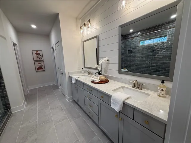 a bathroom with a double vanity sink a mirror and a shower