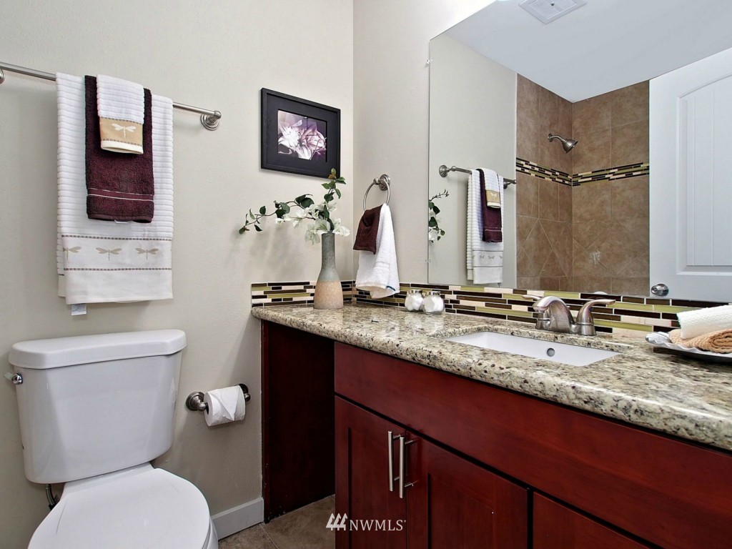 18430 Southeast 135th Street Renton, WA 98059 - Photo 9 of 13 a bathroom with a granite countertop toilet sink and mirror