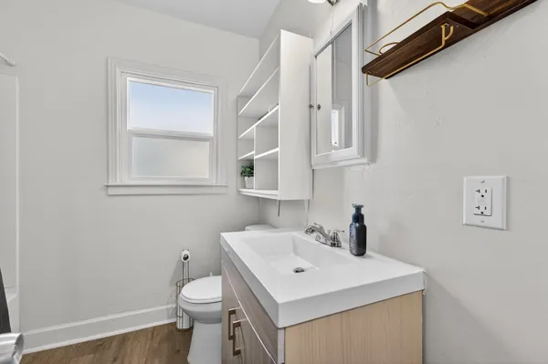 a bathroom with a sink a toilet and mirror