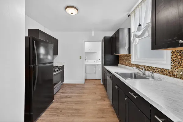 a kitchen with granite countertop a refrigerator and a sink