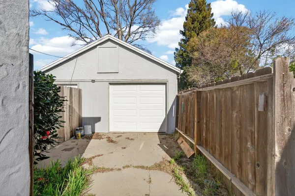 a view of backyard of house with wooden fence