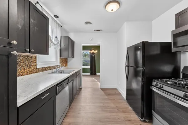 a kitchen with stainless steel appliances granite countertop a refrigerator and a stove