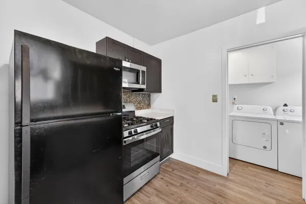 a kitchen with a refrigerator stove and white cabinets