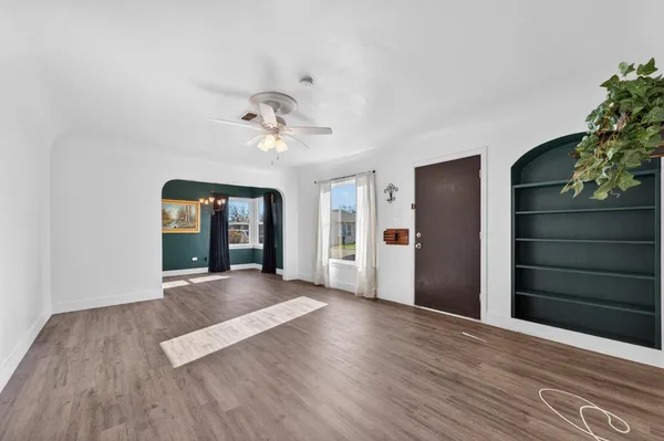 a view of an empty room with wooden floor and cabinet