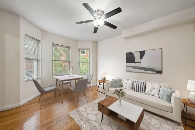 a living room with furniture wooden floor and a window