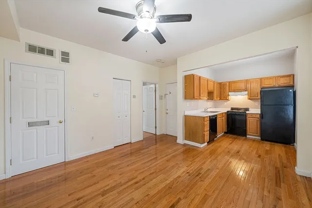a kitchen with a sink cabinets and wooden floor