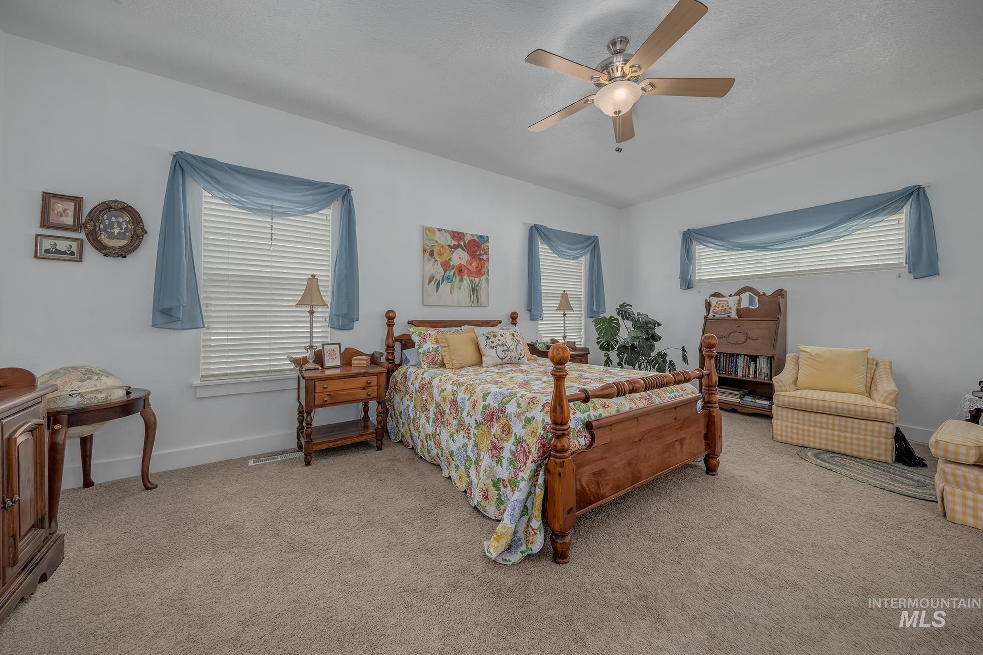 420 West Indianhead Road Weiser, ID 83672 - Photo 22 of 40 Spacious interior featuring carpeted flooring, multiple windows with blinds, and a ceiling fan with integrated lighting