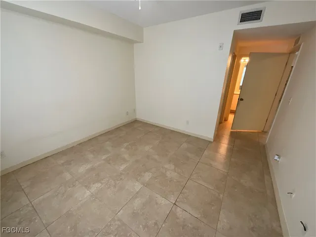 an empty room with mirror and entrance