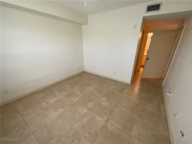 an empty room with wooden floor and mirror