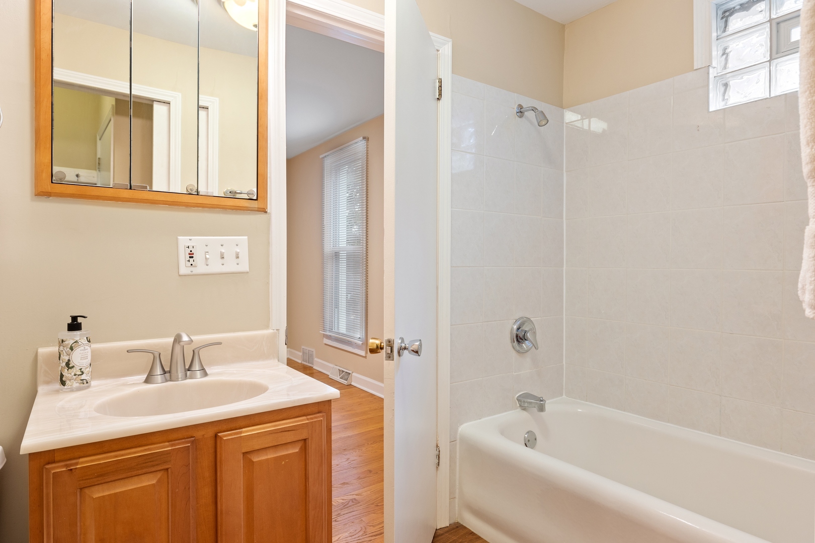 879 Willow Road Winnetka, IL 60093 - Photo 12 of 29 a bathroom with a granite countertop sink a mirror a vanity and a bathtub