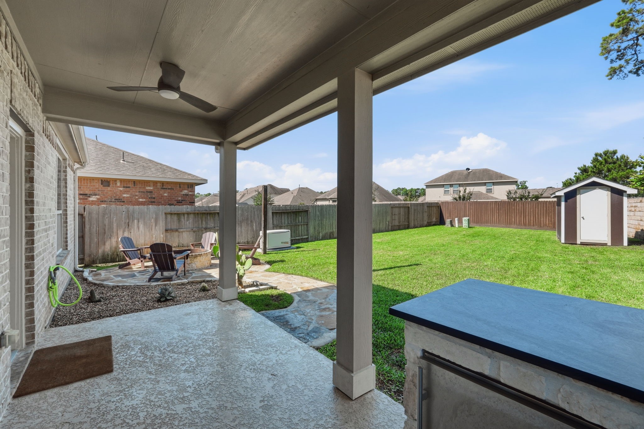 4334 Umber Shadow Drive Spring, TX 77386 - Photo 34 of 45 Covered patio offers panoramic backyard views, vaulted wood-paneled ceilings, and a built-in outdoor kitchen designed for year-round enjoyment. Notice the whole home generator as well.