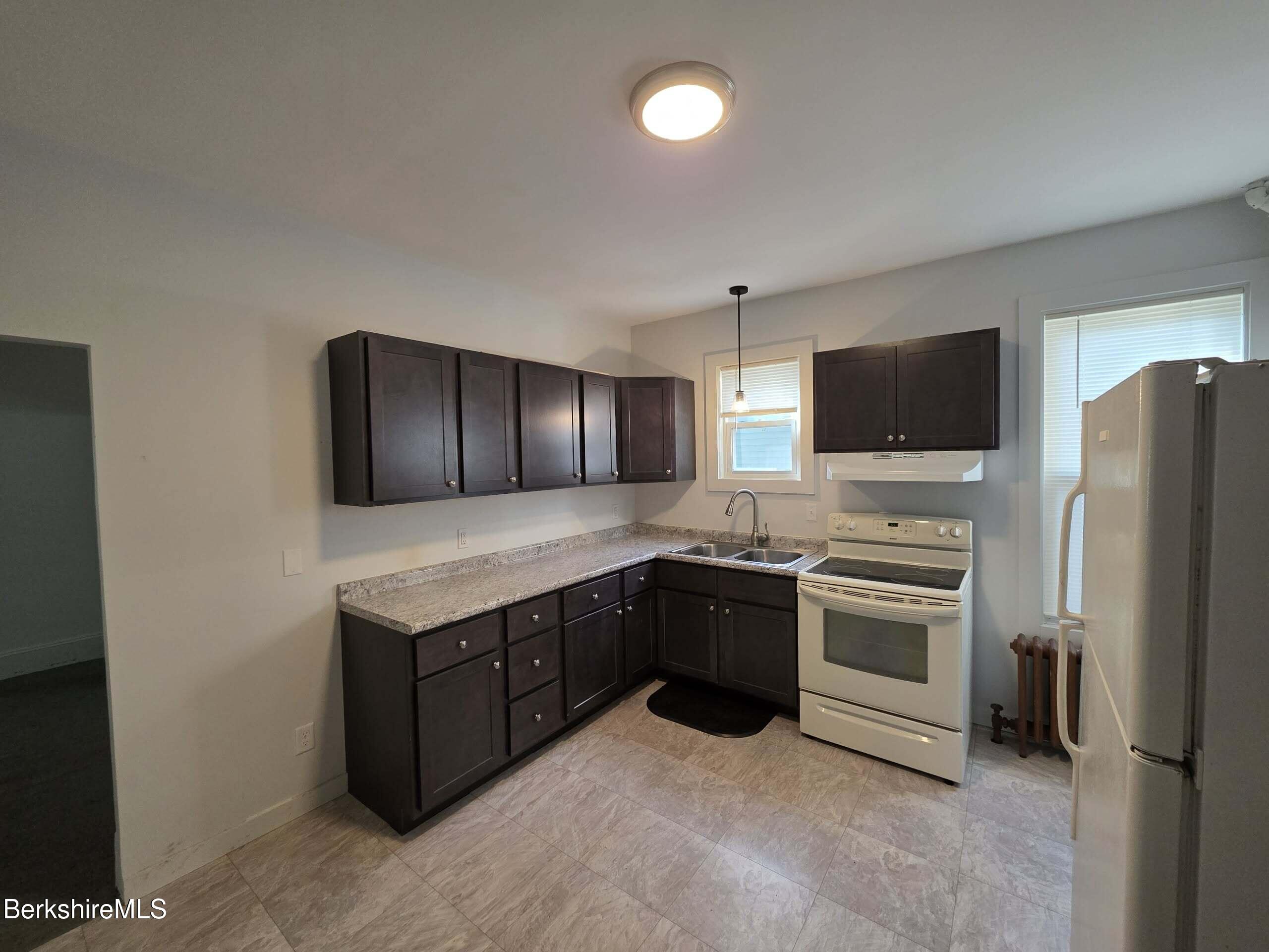 57 Beacon Street, Unit 1 North Adams, MA 01247 - Photo 3 of 10 a kitchen with a stove refrigerator and microwave
