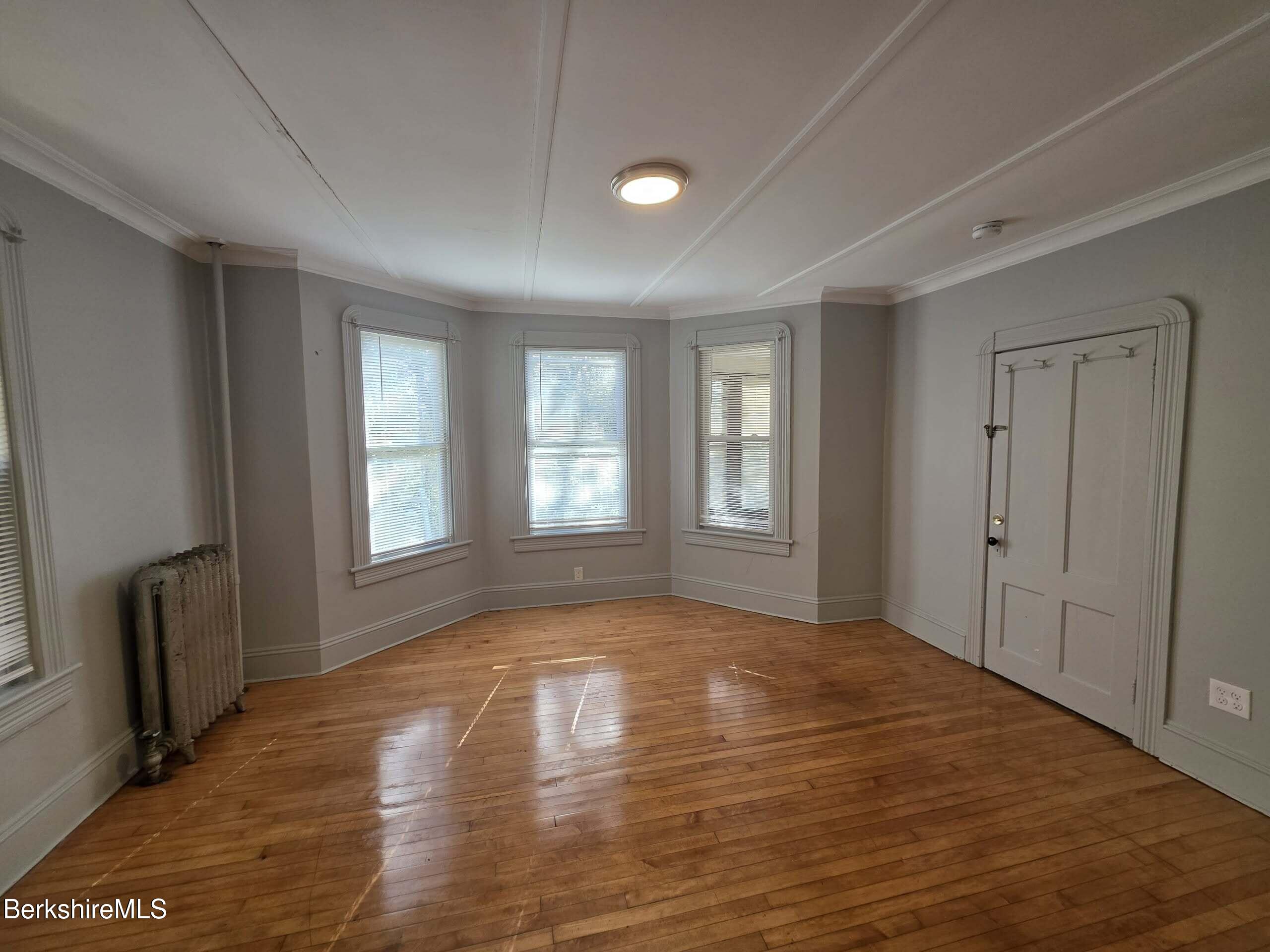 57 Beacon Street, Unit 1 North Adams, MA 01247 - Photo 4 of 10 a view of an empty room with wooden floor and a window