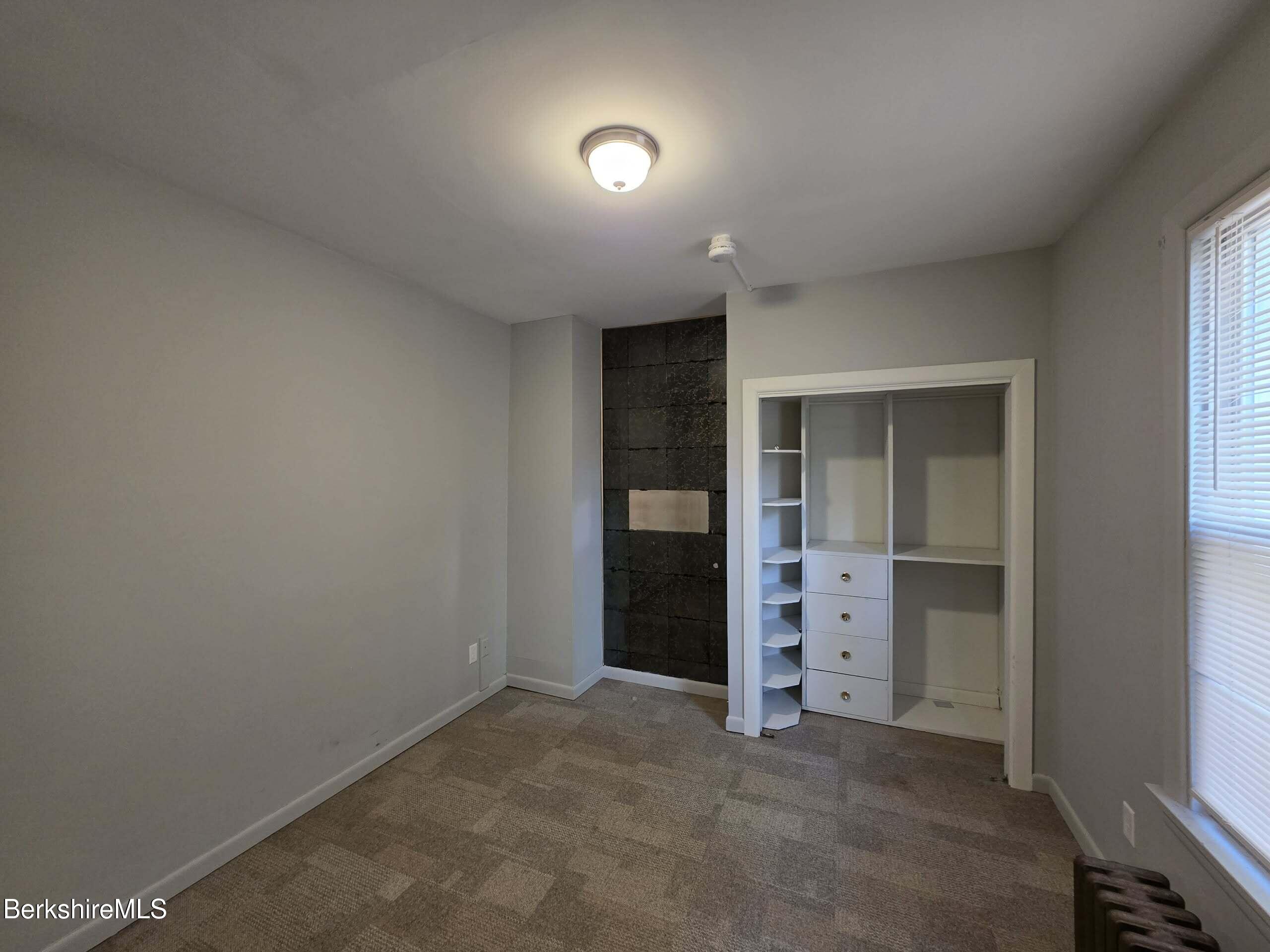 57 Beacon Street, Unit 1 North Adams, MA 01247 - Photo 7 of 10 an empty room with closet and wooden floor