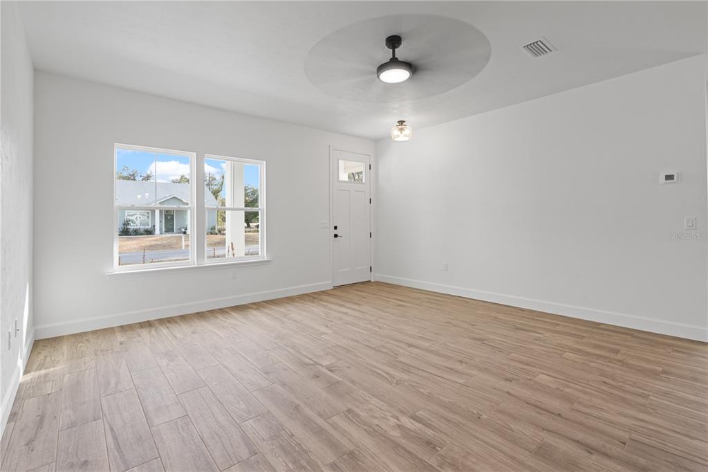 601 Fisher Drive Bronson, FL 32621 - Photo 3 of 32 an empty room with wooden floor and windows