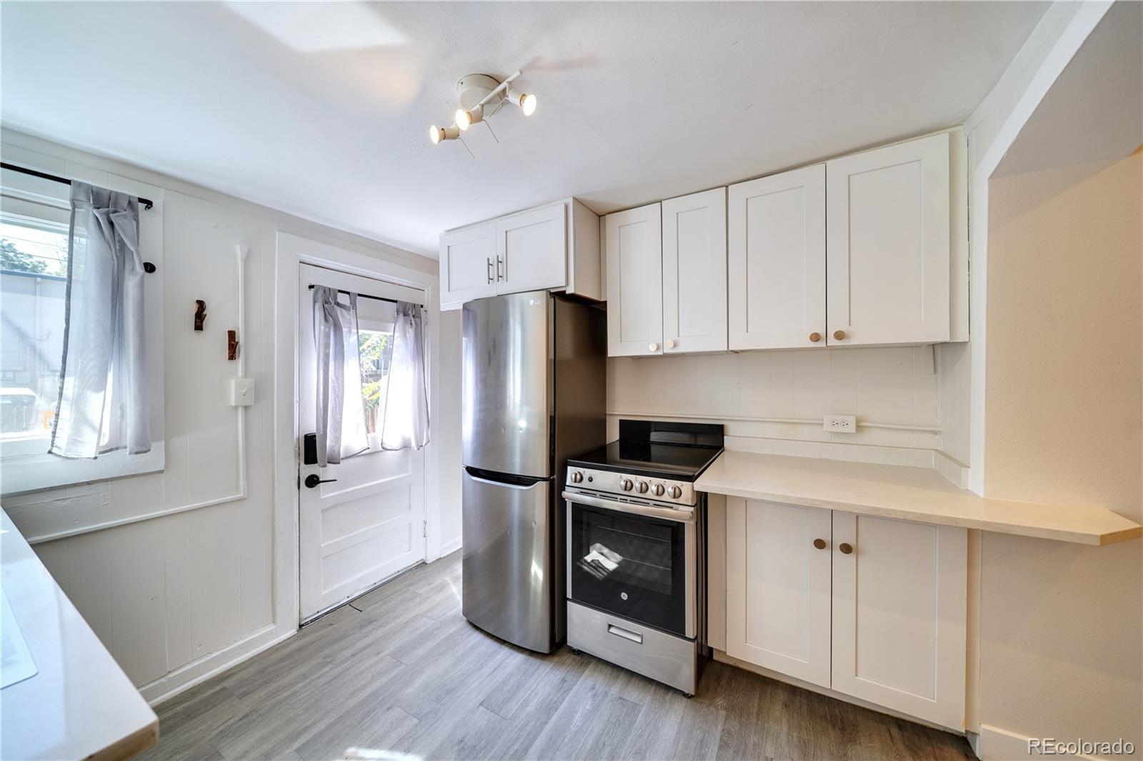 2528 West 23rd Avenue, Unit B Denver, CO 80211 - Photo 4 of 11 a kitchen with cabinets and stainless steel appliances