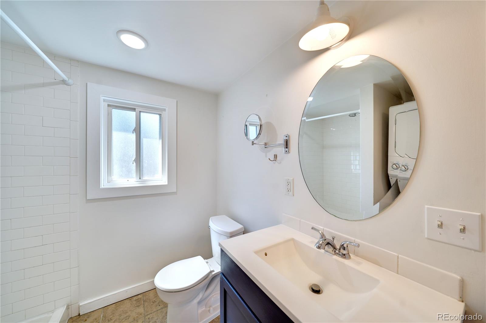2528 West 23rd Avenue, Unit B Denver, CO 80211 - Photo 7 of 11 a bathroom with a toilet sink and mirror