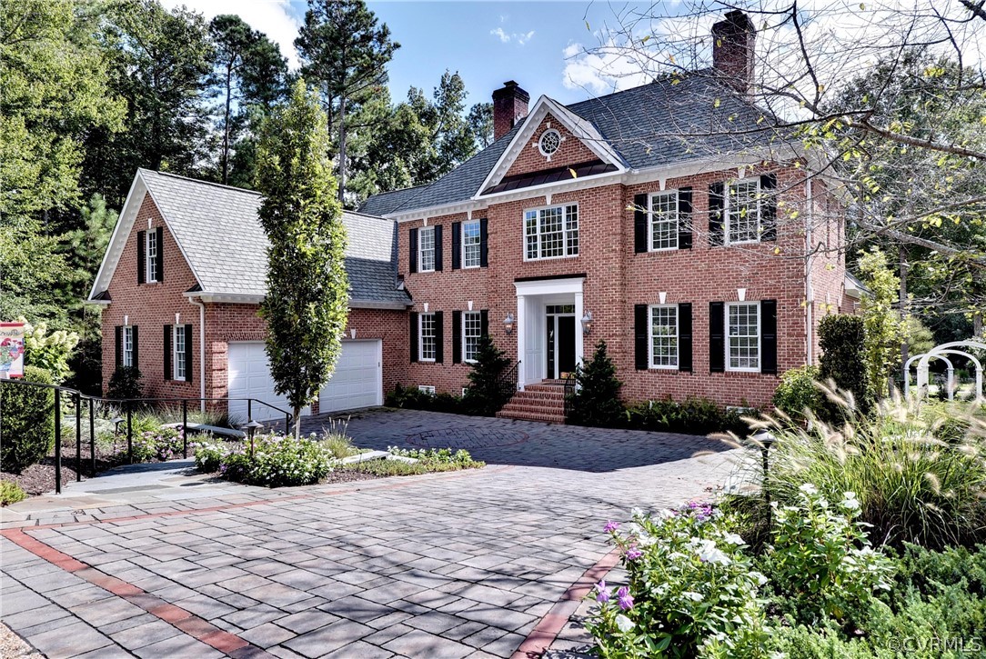 a front view of a house with a yard and potted plants