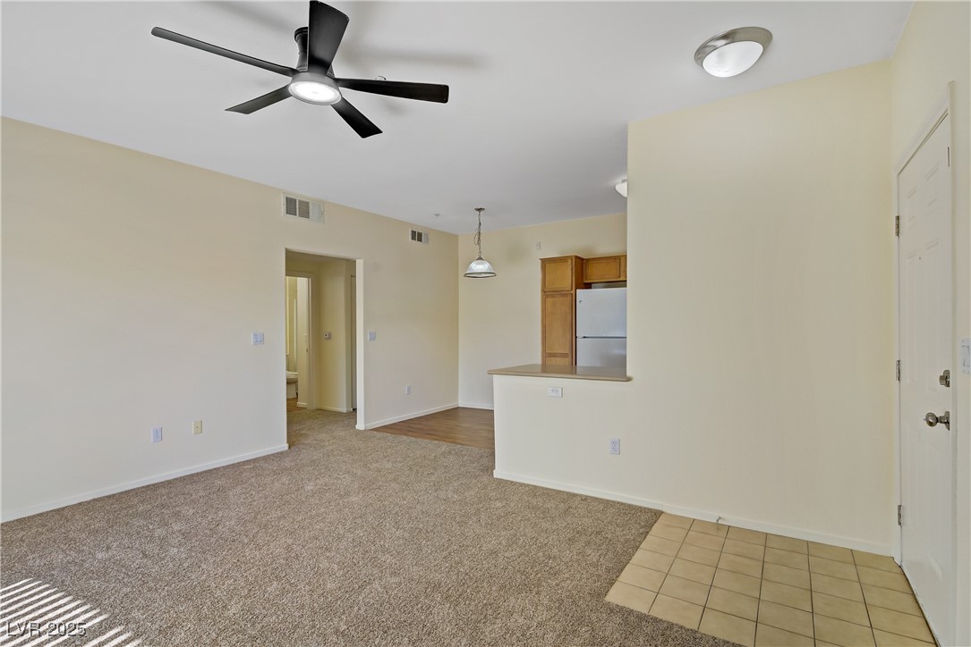 2291 West Horizon Ridge Parkway, Unit 11266 Henderson, NV 89052 - Photo 12 of 40 Unfurnished room with light carpet, a ceiling fan, and light tile patterned floors