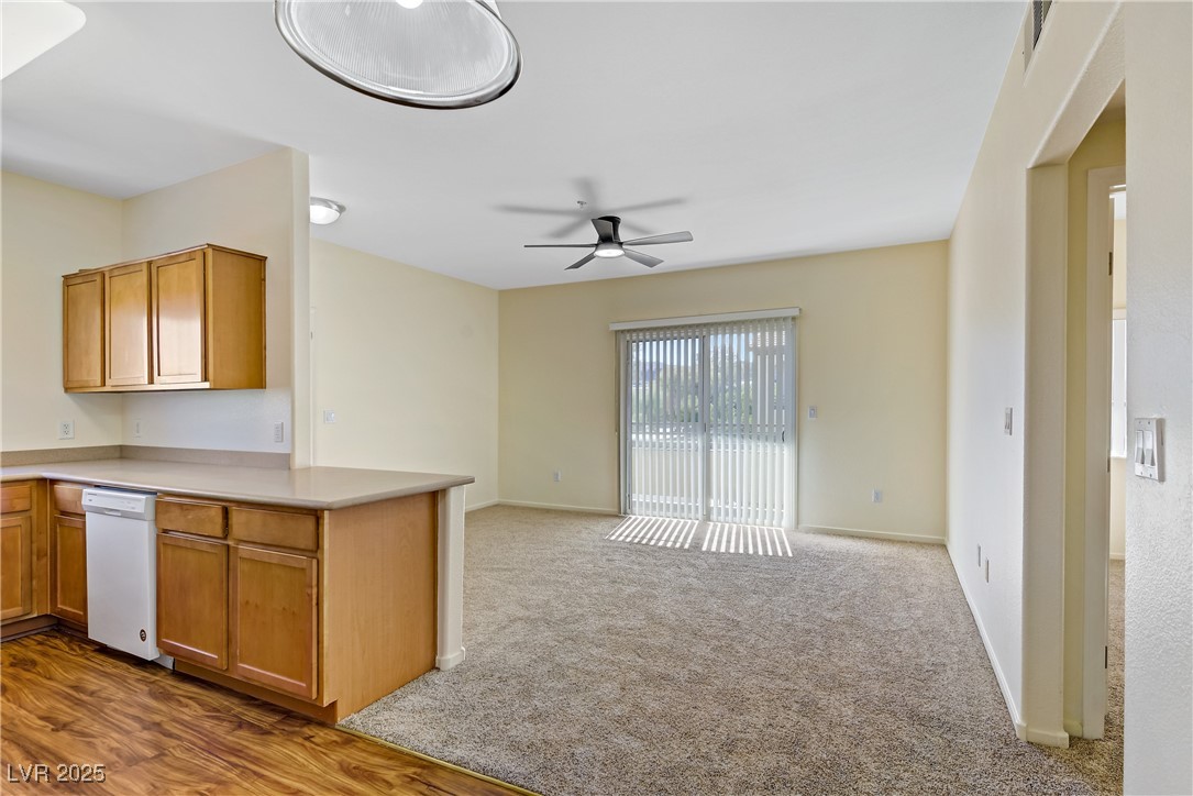 2291 West Horizon Ridge Parkway, Unit 11266 Henderson, NV 89052 - Photo 40 of 40 Kitchen featuring light countertops, dishwasher, brown cabinets, light colored carpet, and open floor plan