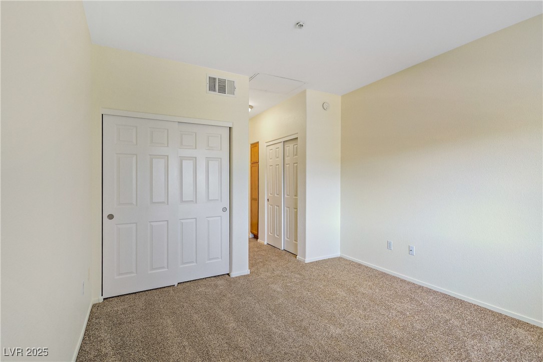 2291 West Horizon Ridge Parkway, Unit 11266 Henderson, NV 89052 - Photo 28 of 40 Unfurnished bedroom with carpet and multiple closets