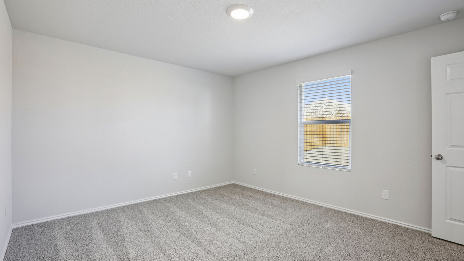 156 Wyatt Way Jarrell, TX 76537 - Photo 16 of 30 Carpeted room featuring a single window with blinds, a ceiling-mounted light fixture, and a paneled interior door