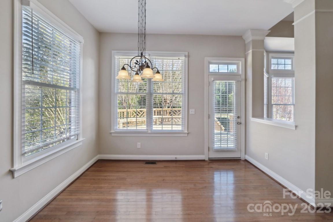 8403 Royster Run Waxhaw, NC 28173 - Photo 6 of 25 a view of an empty room with wooden floor and a window