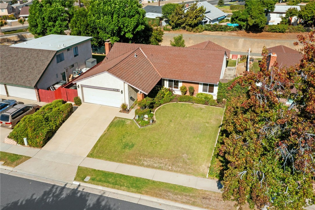 an aerial view of a house with swimming pool and large trees