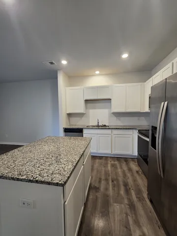 a kitchen with refrigerator cabinets and wooden floor
