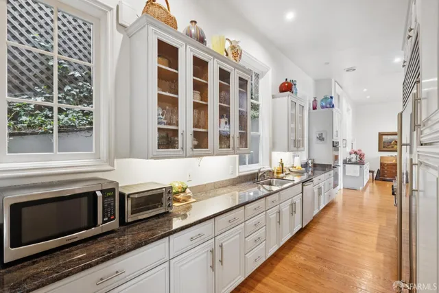a large kitchen with stainless steel appliances a stove and a large window