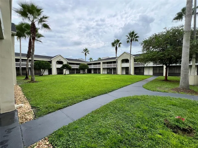 a front view of a house with a yard and potted plants