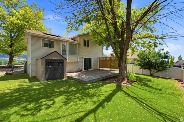 2475 Church Street Layton, UT 84040 - Photo 22 of 27 Expansive backyard featuring a large wooden deck, mature shade tree, manicured lawn, and a storage shed