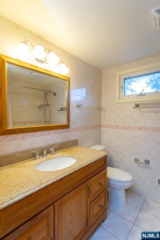397 Hickory Avenue Paramus, NJ 07652 - Photo 13 of 14 a bathroom with a granite countertop sink a toilet and a mirror